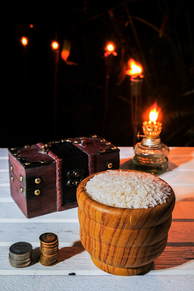 Rice,In,Wooden,Bowl,And,Coin,With,Oil,Lamp,At